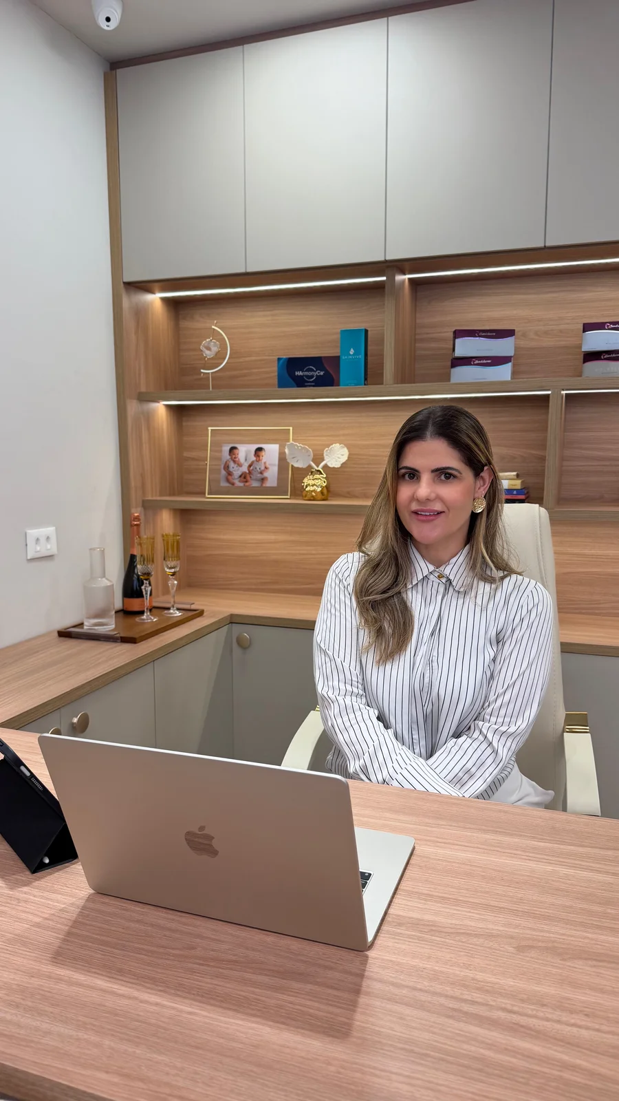 Dra. Taiana Pires Matos sentada à mesa do consultório, durante um atendimento
